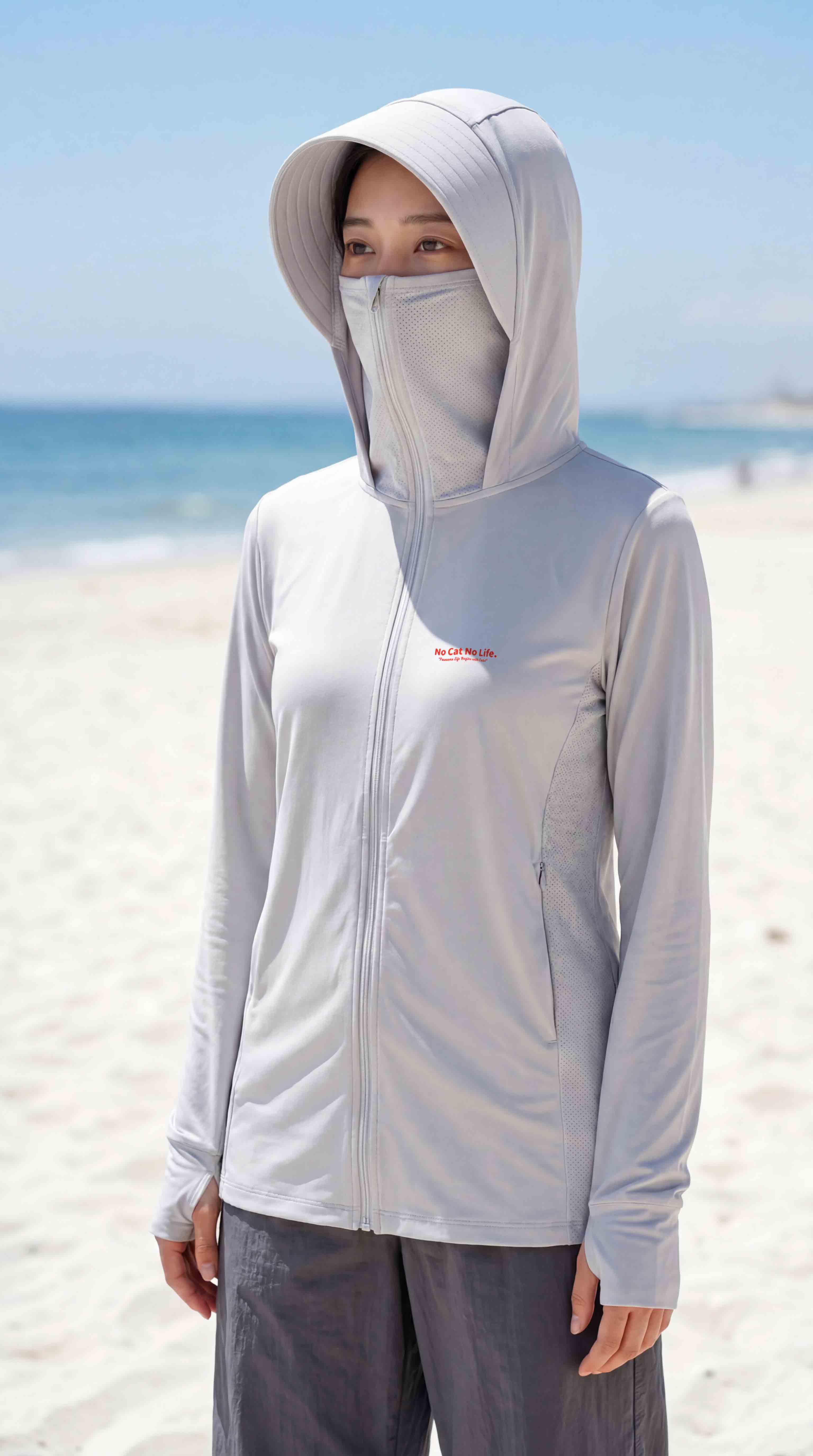 海辺で面マスクを上げた完全防備姿・白系のNEKONI UV HOODIE着用